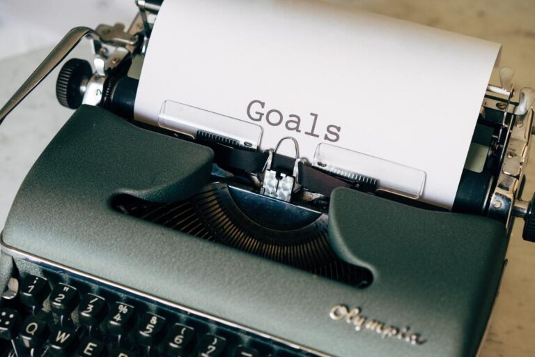 Close-up of a typewriter displaying the word "goals" on paper