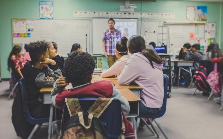 A teacher stands in front of a classroom