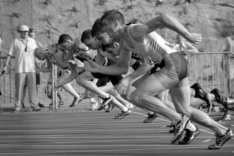 Black and white photo of men sprinting on a track